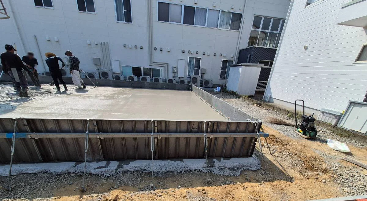 型枠に囲まれた基礎へコンクリートを流し入れる様子