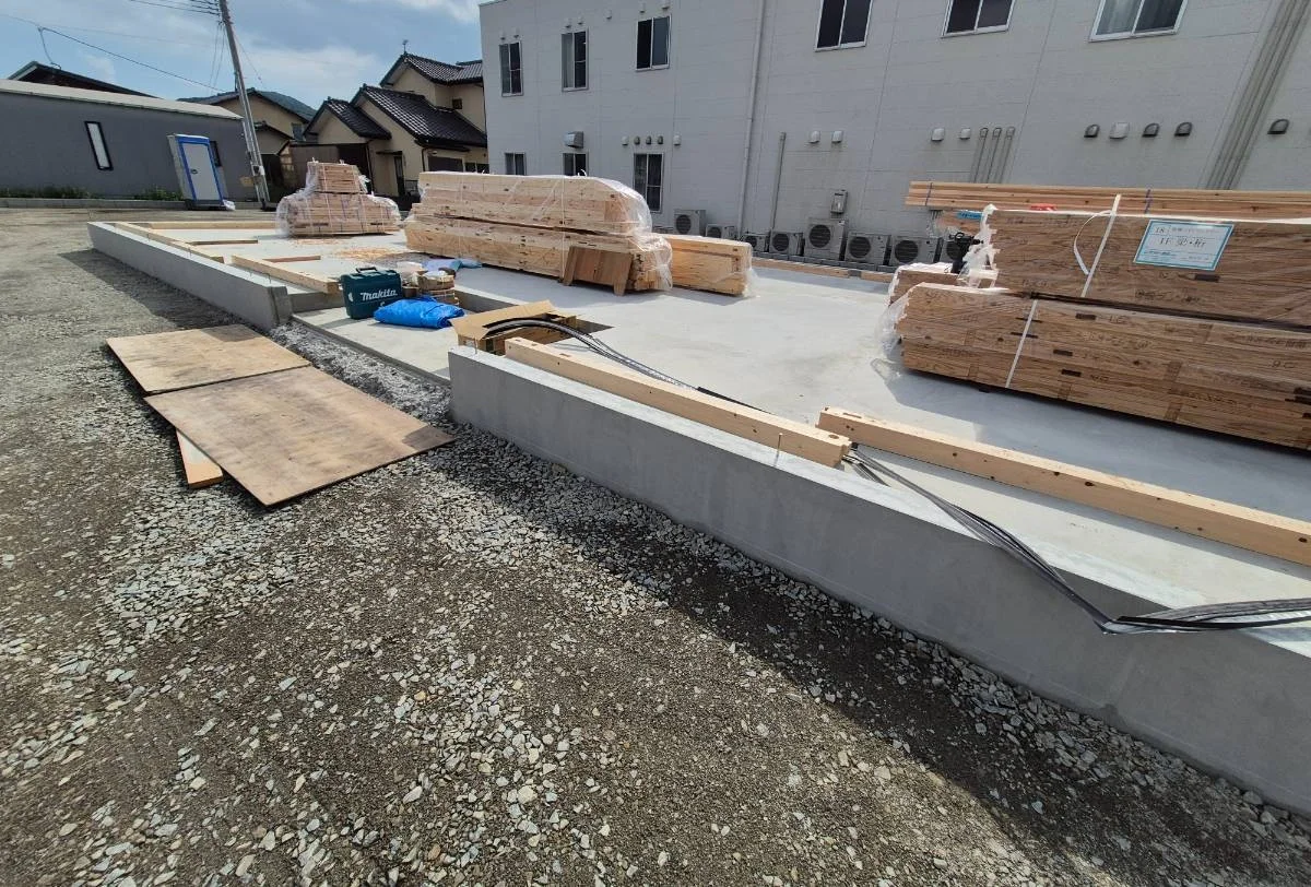 基礎の上に木材を仮置きした建設現場